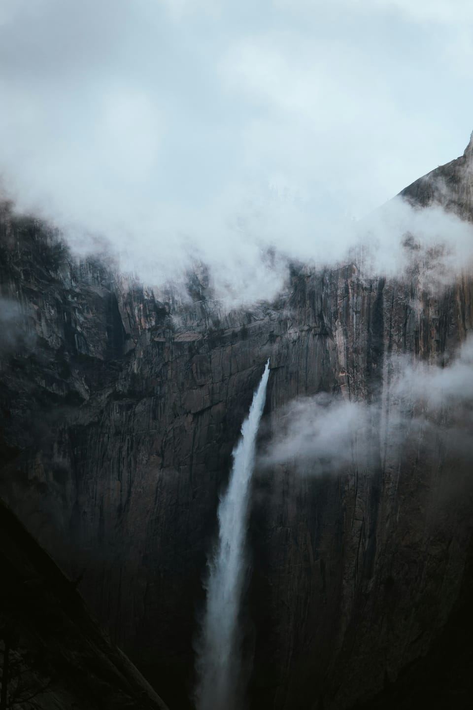 A Yosemite waterfall cutting through mist and granite